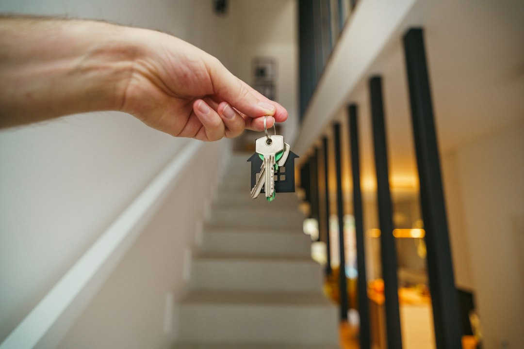 A close-up of a host's hand giving a set of house keys directly to a guest, symbolizing a direct booking and a personal connection.