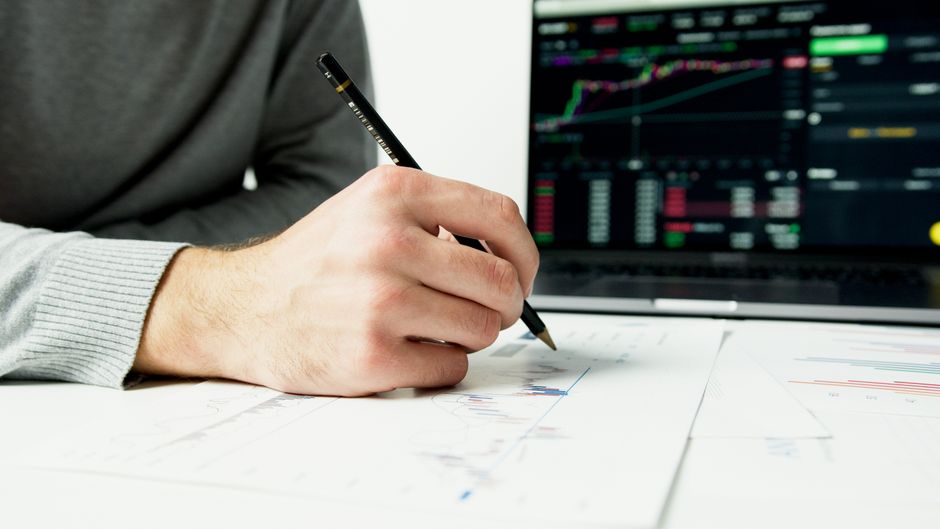 A professionally dressed real estate agent in a bright, modern office analyzing data on a futuristic transparent screen, representing strategic planning.