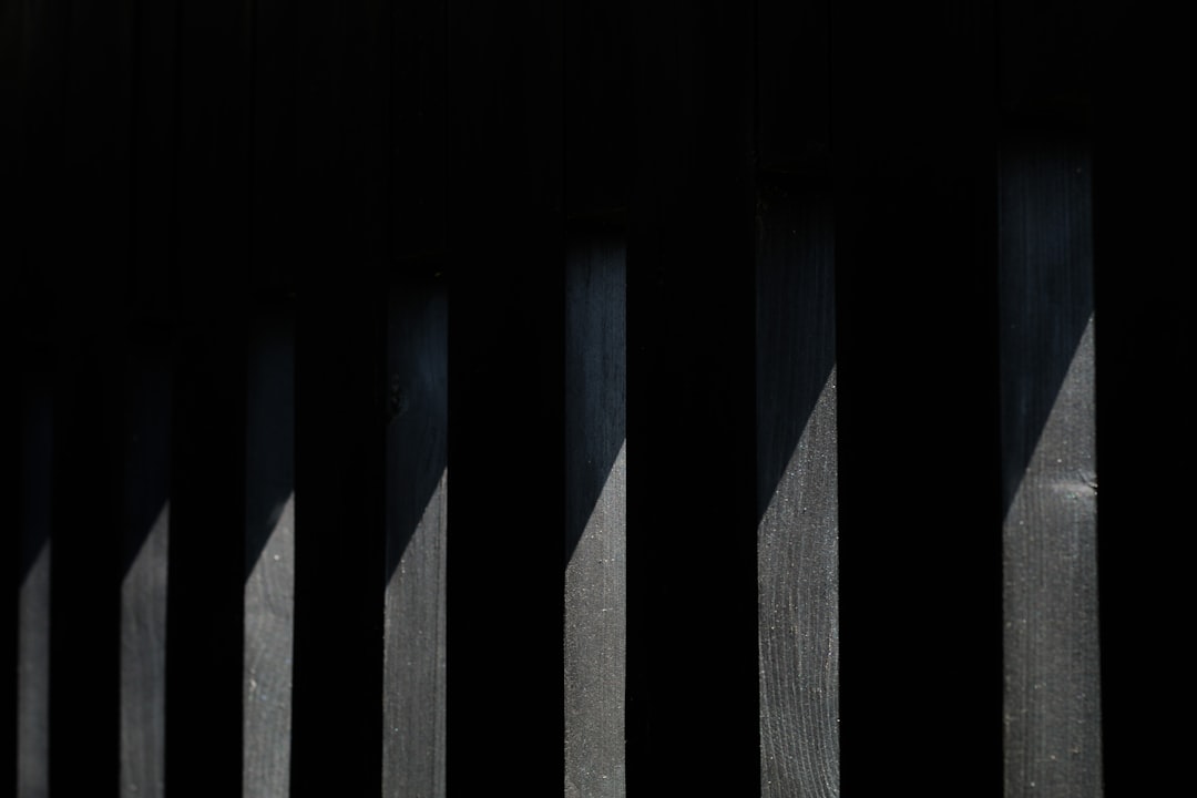 A single, minimalist architectural model of a modern home illuminated by a spotlight against a dark background, signifying being featured and standing out.