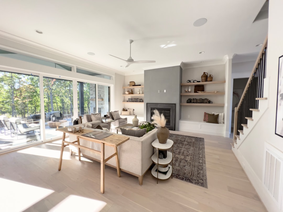 Two smiling real estate agents stand with a happy couple in front of a beautiful modern home, illustrating the successful outcome and client satisfaction achieved by a team.